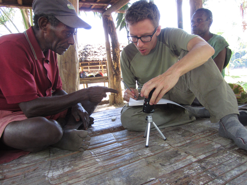 Graduate student Joseph Brooks working with a consultant in Papua New Guinea