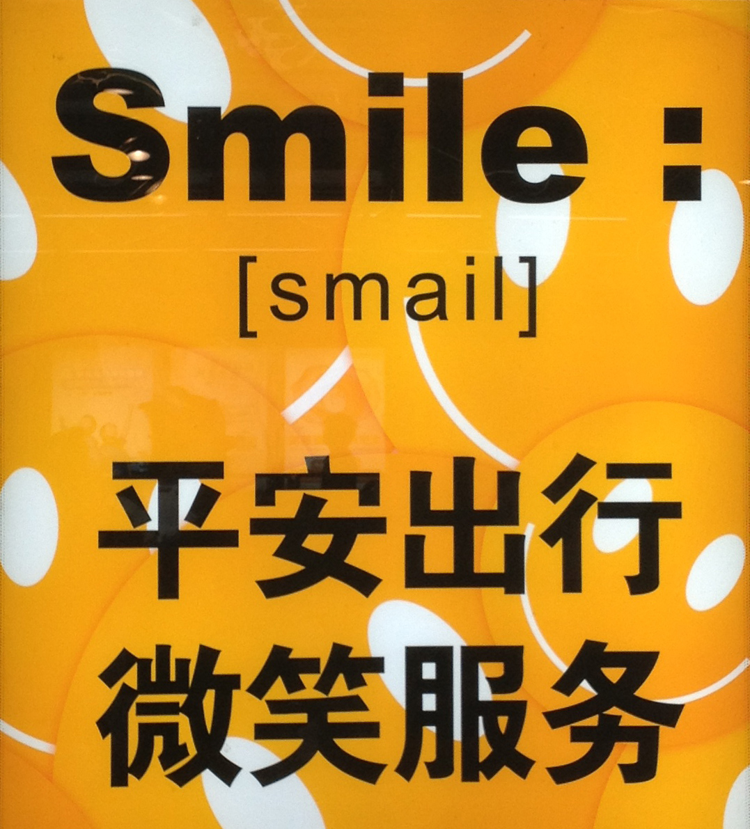 A sign with the word "Smile" written in a variety of ways